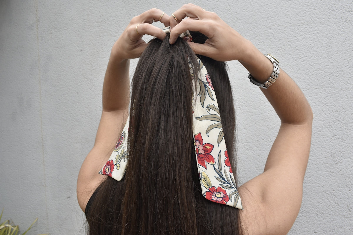 a woman with long hair is putting on a bandana