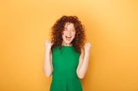 a woman in a green dress is laughing