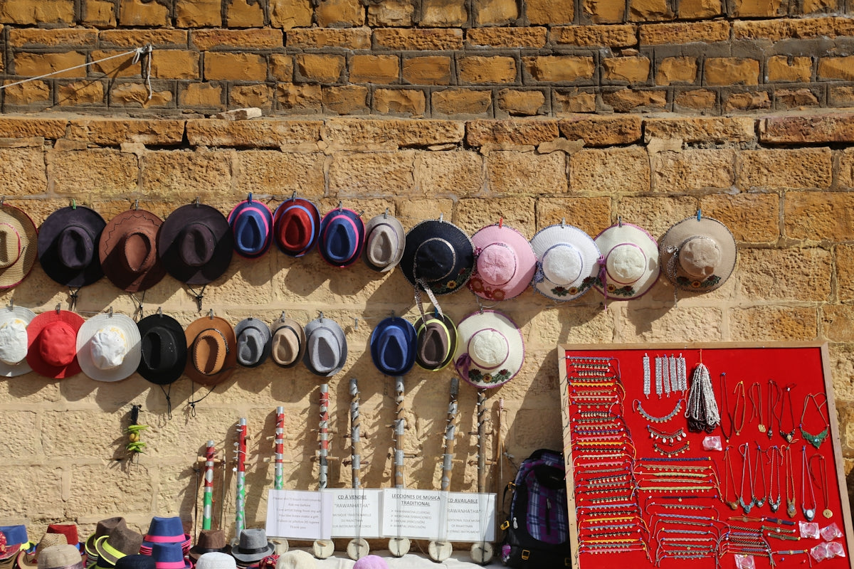 Hats, jewelry and walking sticks displayed on a wall.