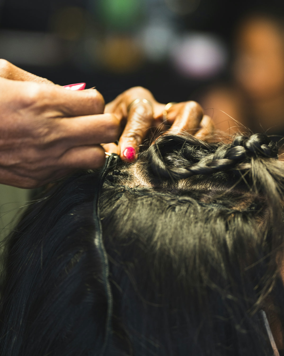 Hands braiding hair with extensions