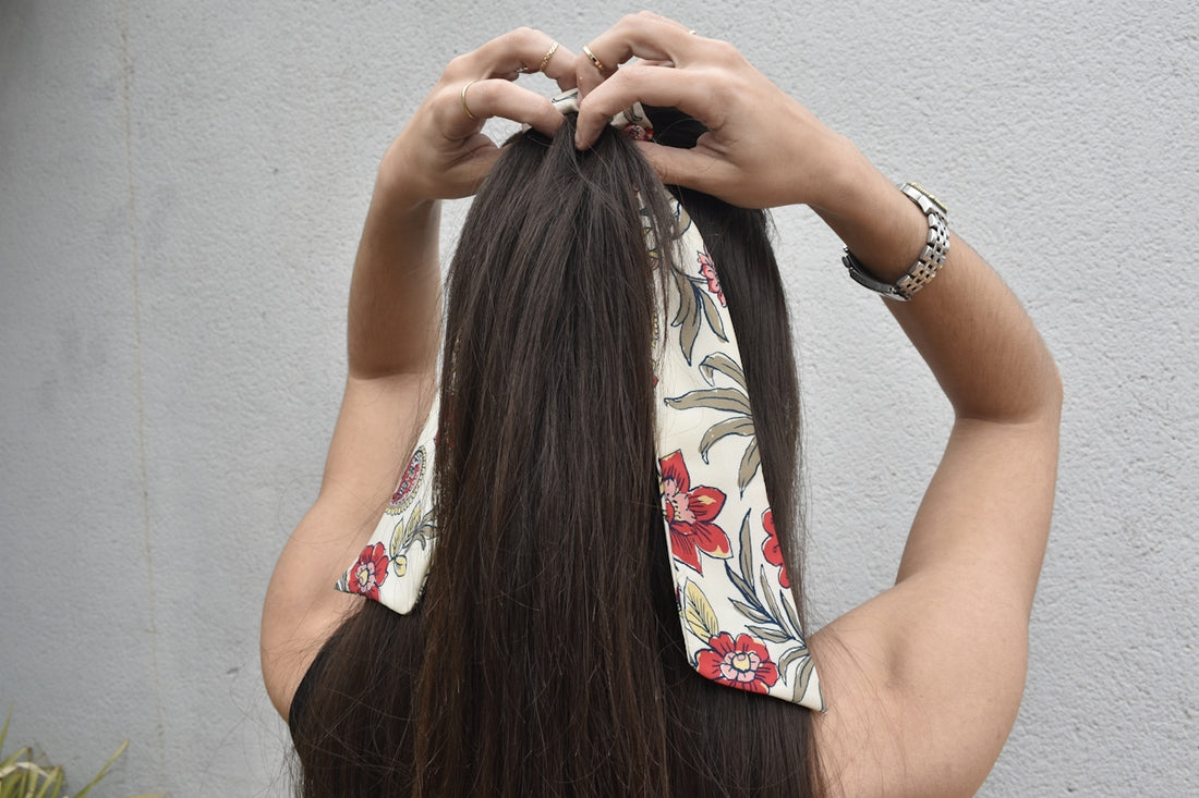 a woman with long hair is putting on a bandana