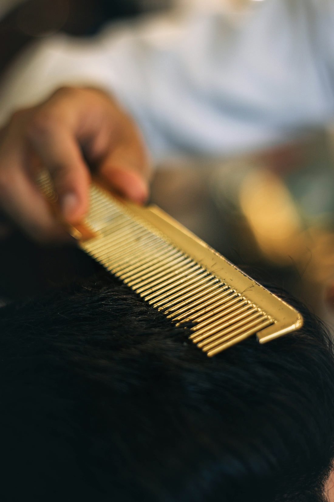 a close up of a person cutting a mans hair