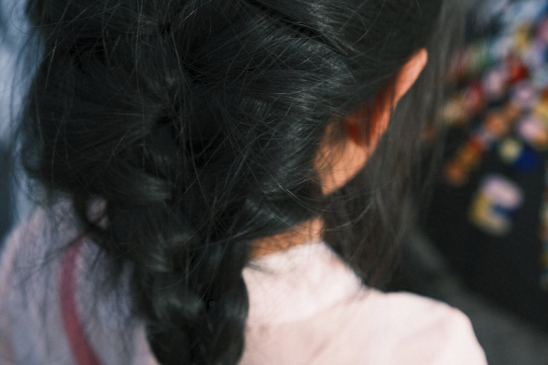 a close up of a woman's hair with a flower in her hair