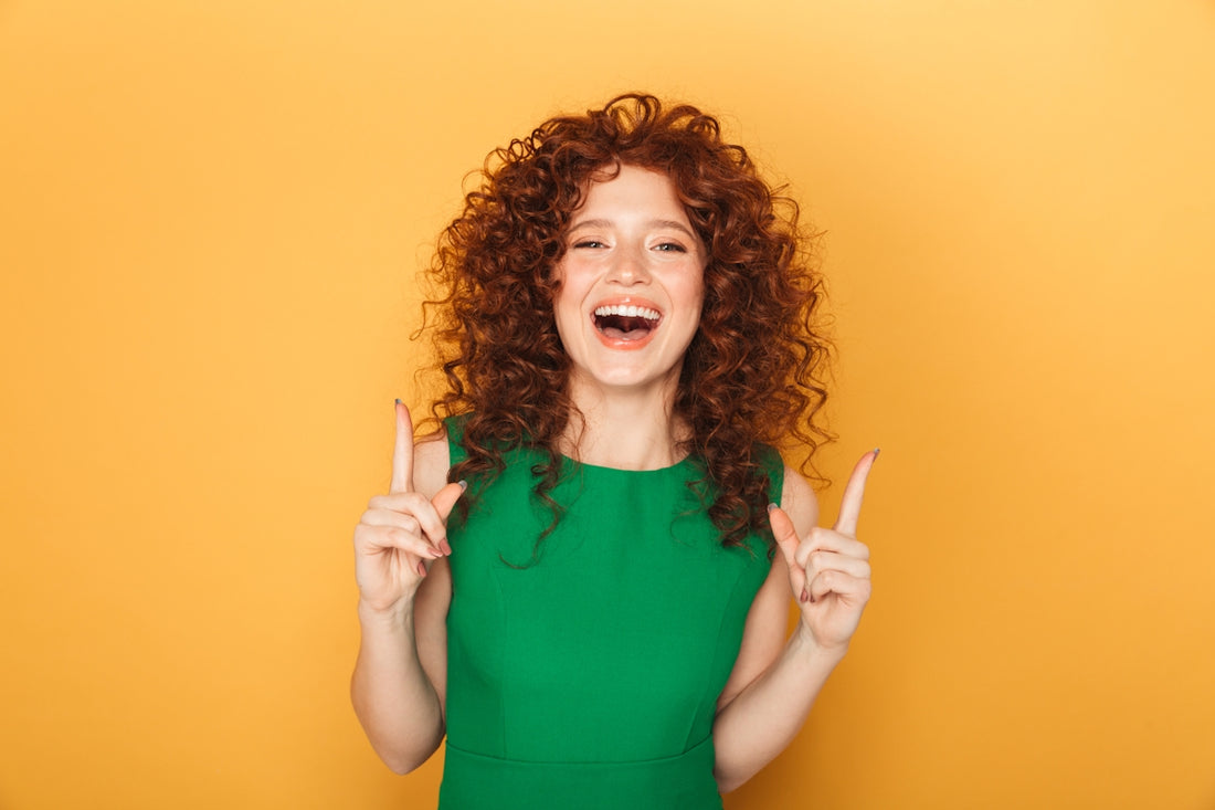 a woman in a green dress holding two fingers up